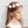 Girl wearing a girls communion pearl floral crown with veil.