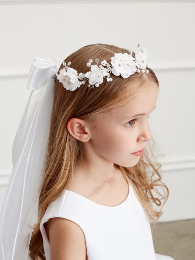 Girl wearing a girls communion pearl floral crown with veil.