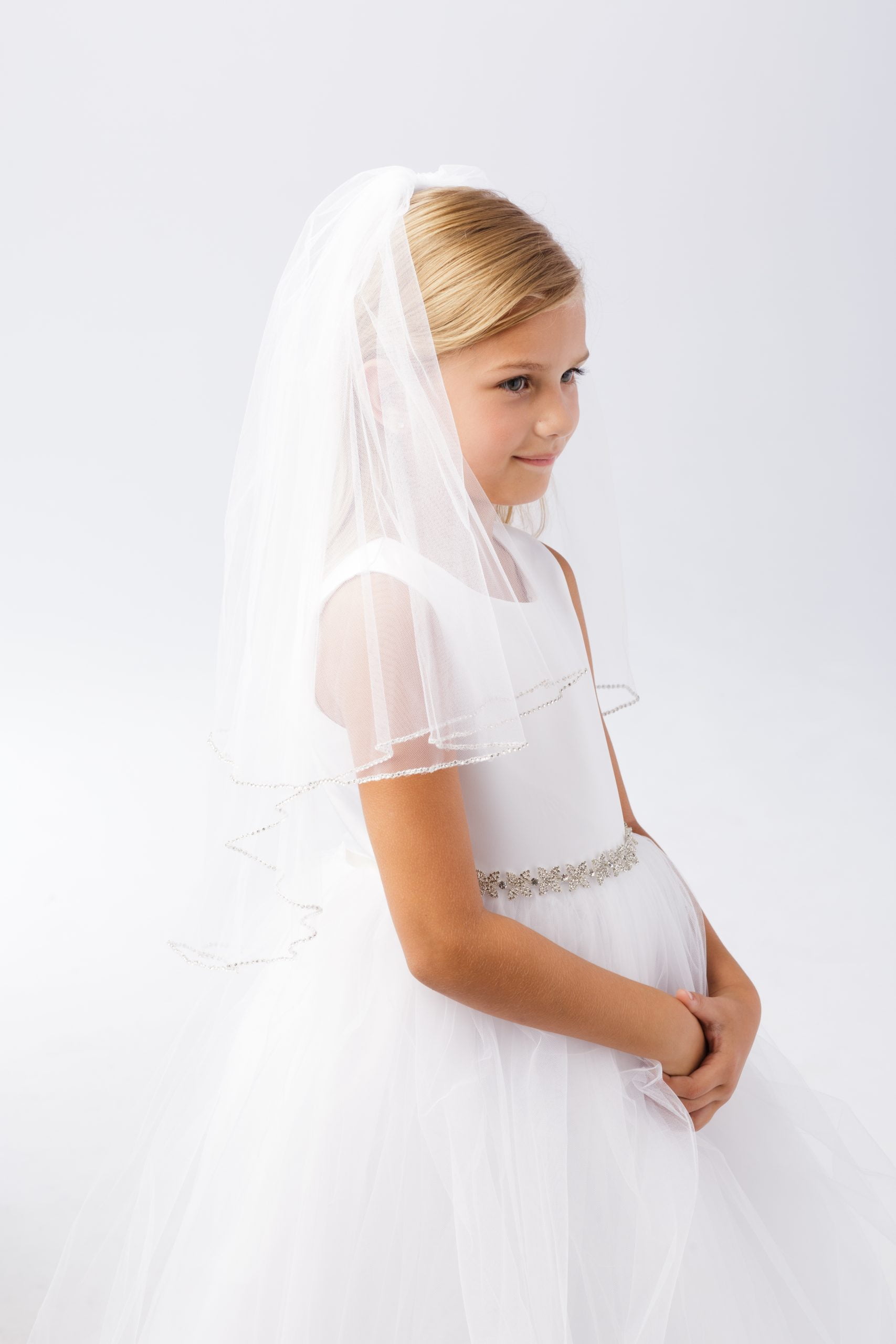 690 Girl wearing a girls communion veil simple style with white dress.