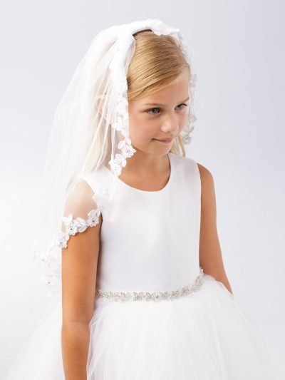 Girl wearing a girls communion veil lace design with floral trim.
